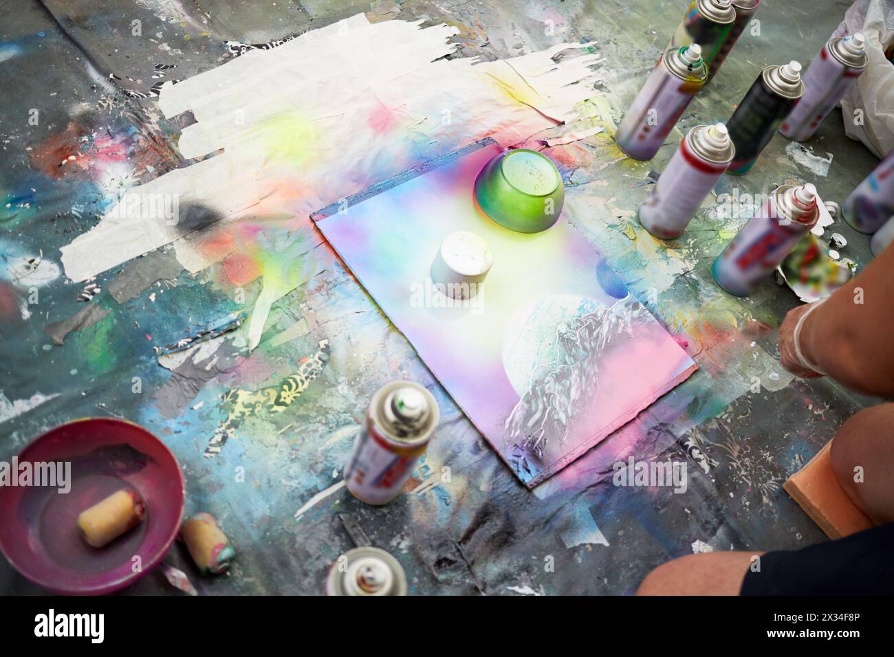 Il giovane disegna un quadro con vernici spray. Foto Stock