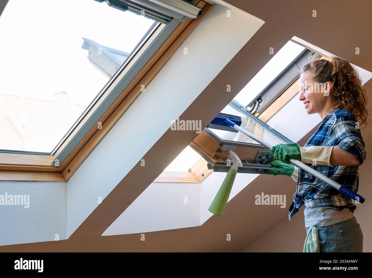 Lavori domestici e stile di vita domestico. La donna lava le finestre nel suo appartamento. Foto Stock