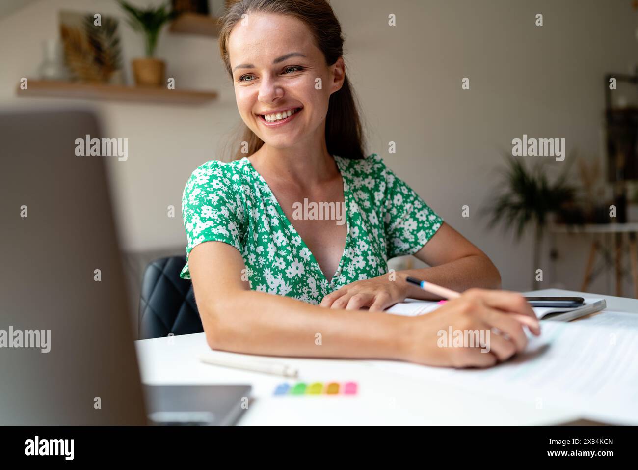 Concetto di studenti adulti. Donna adulta che studia online a casa usando il suo laptop, videochiama il suo tutor. Foto Stock