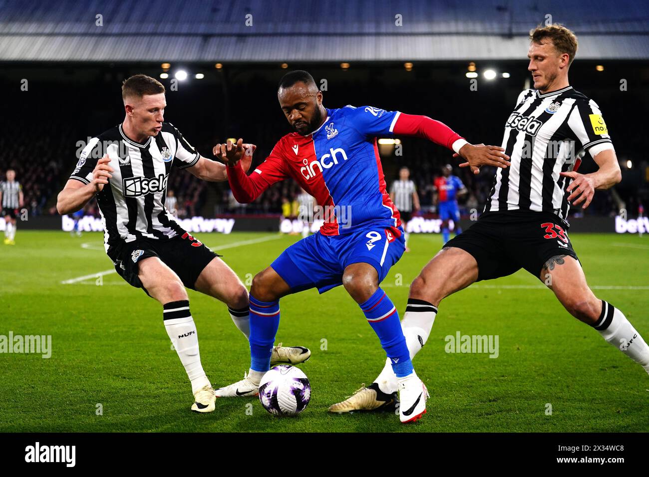 Jordan Ayew (centro) di Crystal Palace combatte per il pallone con Elliot Anderson (sinistra) del Newcastle United e Dan Burn durante la partita di Premier League al Selhurst Park di Londra. Data foto: Mercoledì 24 aprile 2024. Foto Stock