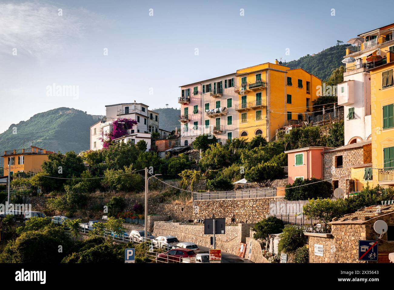 Corniglia, Italia - 11 luglio 2023: Veduta di palazzi colorati su una collina in una giornata di sole a Corniglia, cinque Terre, Italia Foto Stock
