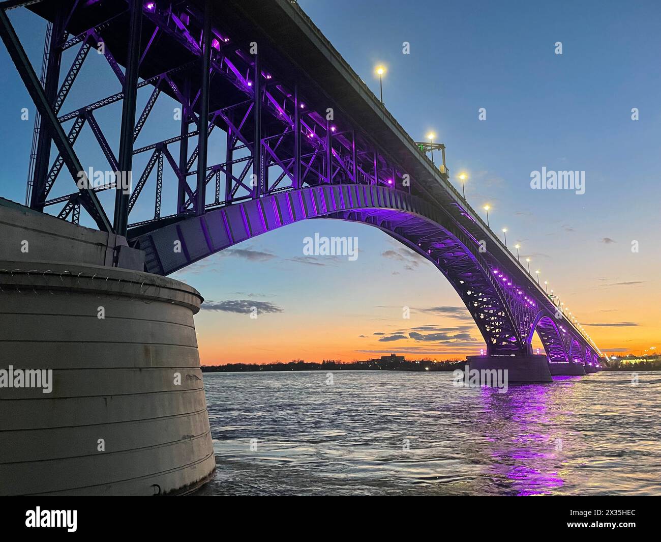 L'International Peace Bridge che collega gli Stati Uniti e il Canada, tra Buffalo, New York e Fort Erie, Ontario, è stato illuminato con luce viola il 15 aprile 2024 per evidenziare il mese del bambino militare. Il viola fa riferimento all'ambiente comune delle forze armate, che comprende tutte le filiali di servizio, Active Duty, Reserve, National Guard e Veterans. Il viola combina i colori di ogni ramo in un unico colore. (Foto U.S. Air Force del Senior Master Sgt. Andrew Caya) Foto Stock