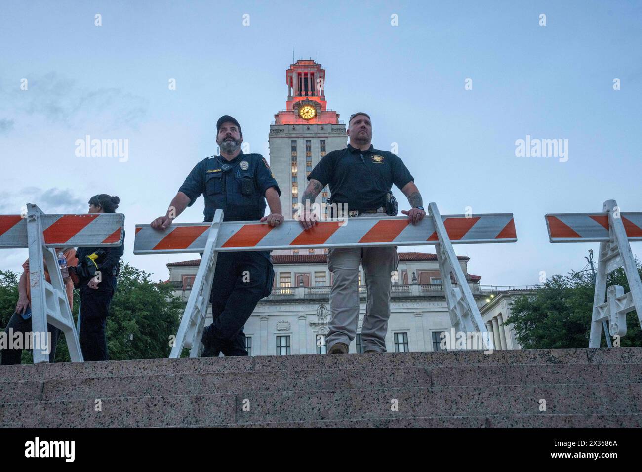 Austin Texas USA, 24 aprile 2024: Gli agenti di polizia dell'Università del Texas ad Austin sorvegliano il South Mall mentre i sostenitori del Palestine Solidarity Committee (PSC) si riuniscono per una protesta pacifica contro la guerra a Gaza in tarda serata davanti alla UT Tower. All'inizio della giornata, una marcia pacifica di protesta pro-palestinese ha portato a più di 50 arresti nel campus dopo il Texas Gov. Greg Abbott ha ordinato ai soldati del Dipartimento di pubblica sicurezza del Texas (DPS) di entrare sulla scena, aumentando le tensioni durante la protesta di un giorno. Crediti: Bob Daemmrich/Alamy Live News Foto Stock
