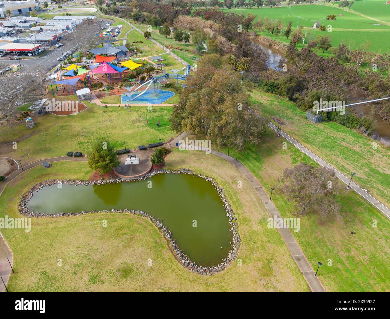Veduta aerea di un parco giochi e di un lago nel parco tra i terreni agricoli e una strada cittadina a Tamworth nel nuovo Galles del Sud, Australia. Foto Stock