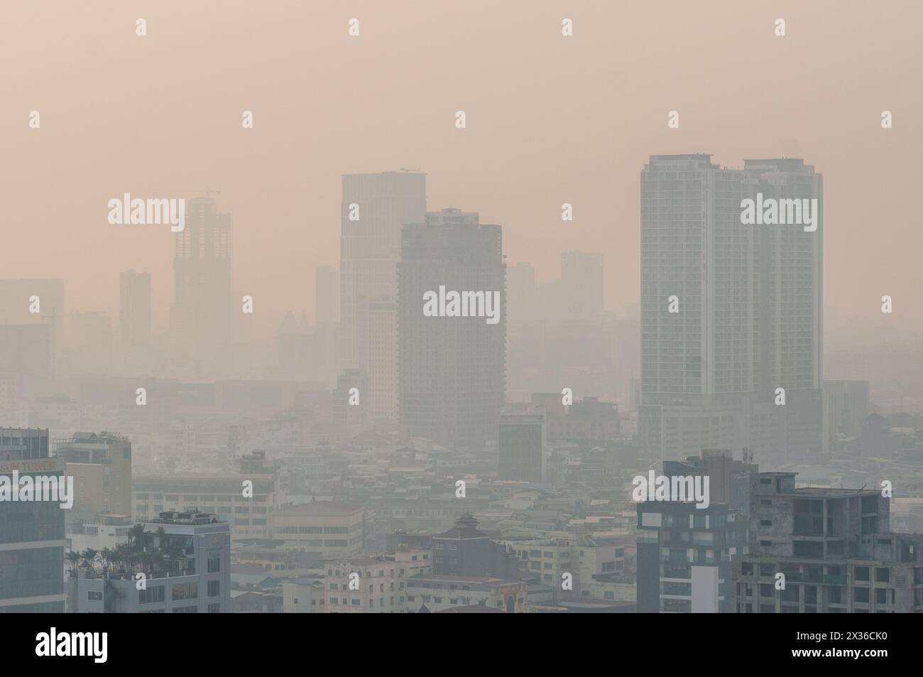 L'inquinamento atmosferico avvolge lo skyline del centro di Phnom Penh durante la stagione calda, Phnom Penh, Cambogia. 21 aprile 2024. © Kraig Lieb Foto Stock