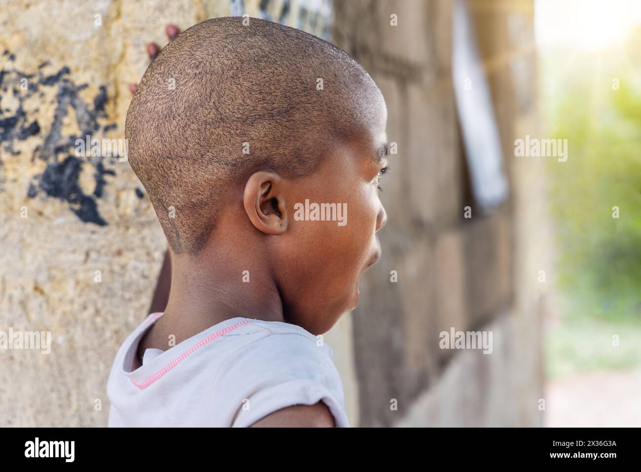 ragazza africana del villaggio assonnata sbadigliando, stanca all'aperto di fronte alla casa nel cortile, Foto Stock