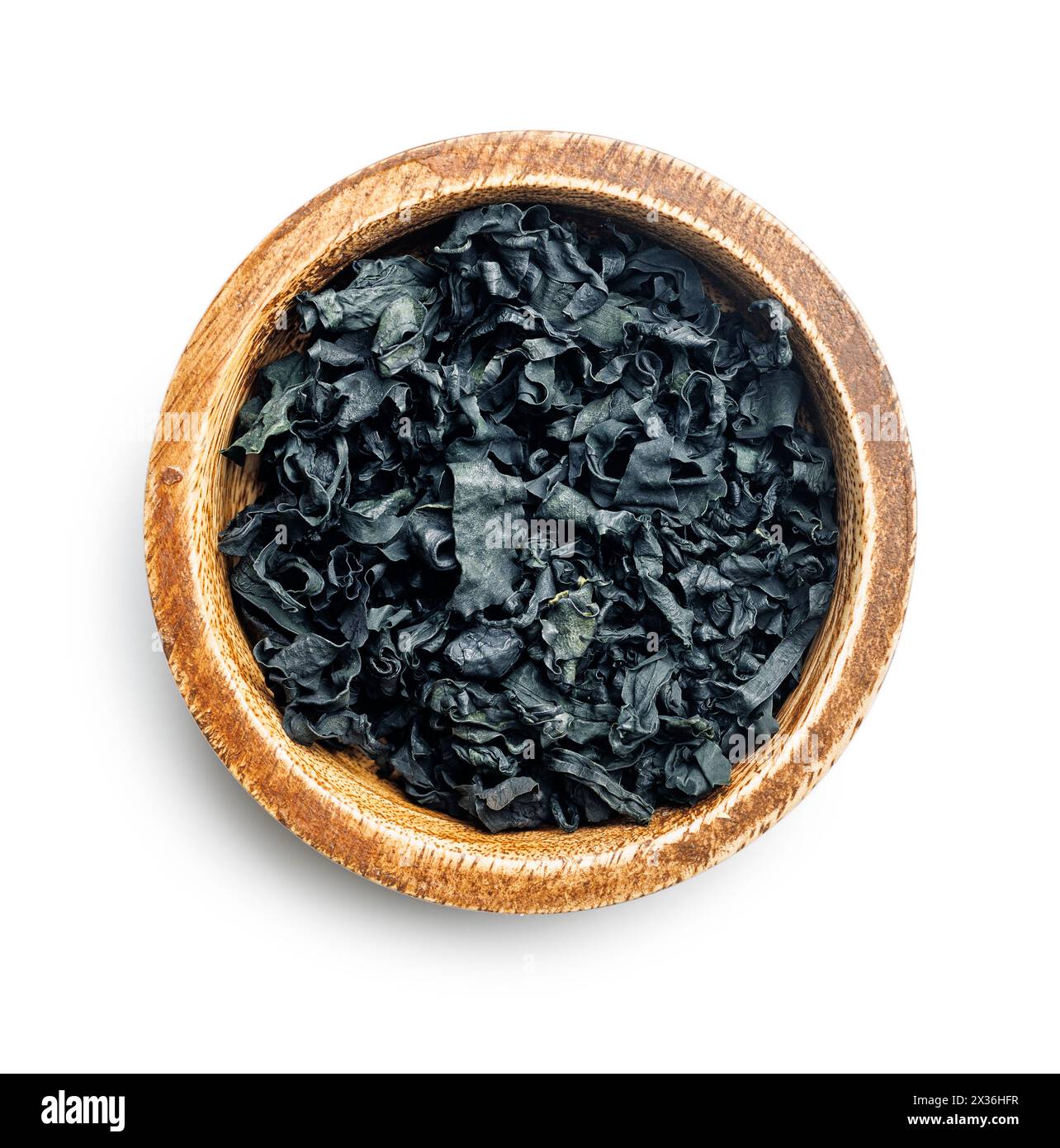 Alghe wakame essiccate in una ciotola isolata su sfondo bianco. Foto Stock
