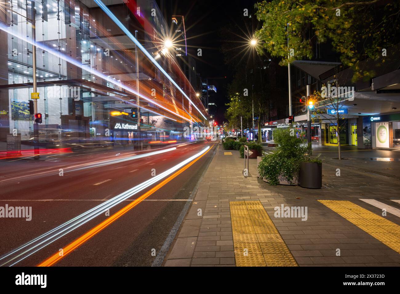 Auckland, nuova Zelanda - 1 luglio 2023: Immagine a lunga esposizione di Queen Street di notte con percorsi leggeri dell'autobus che passano attraverso la strada. Foto Stock
