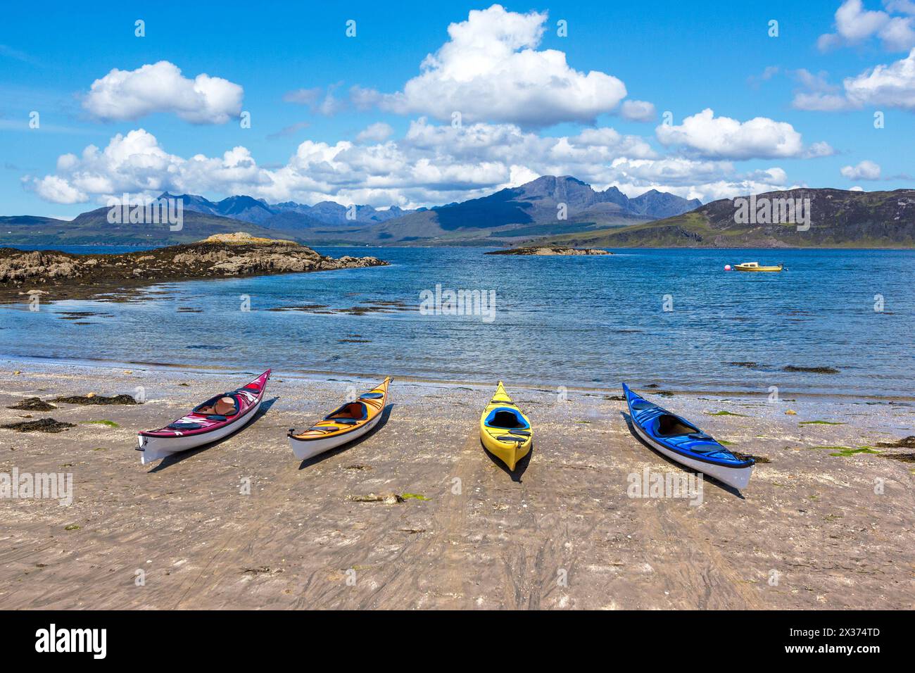 Quattro kayak da mare sulla spiaggia sabbiosa con Loch Eishort e le montagne Cuillin in lontananza, Ord, Isola di Skye, Scozia, Regno Unito Foto Stock