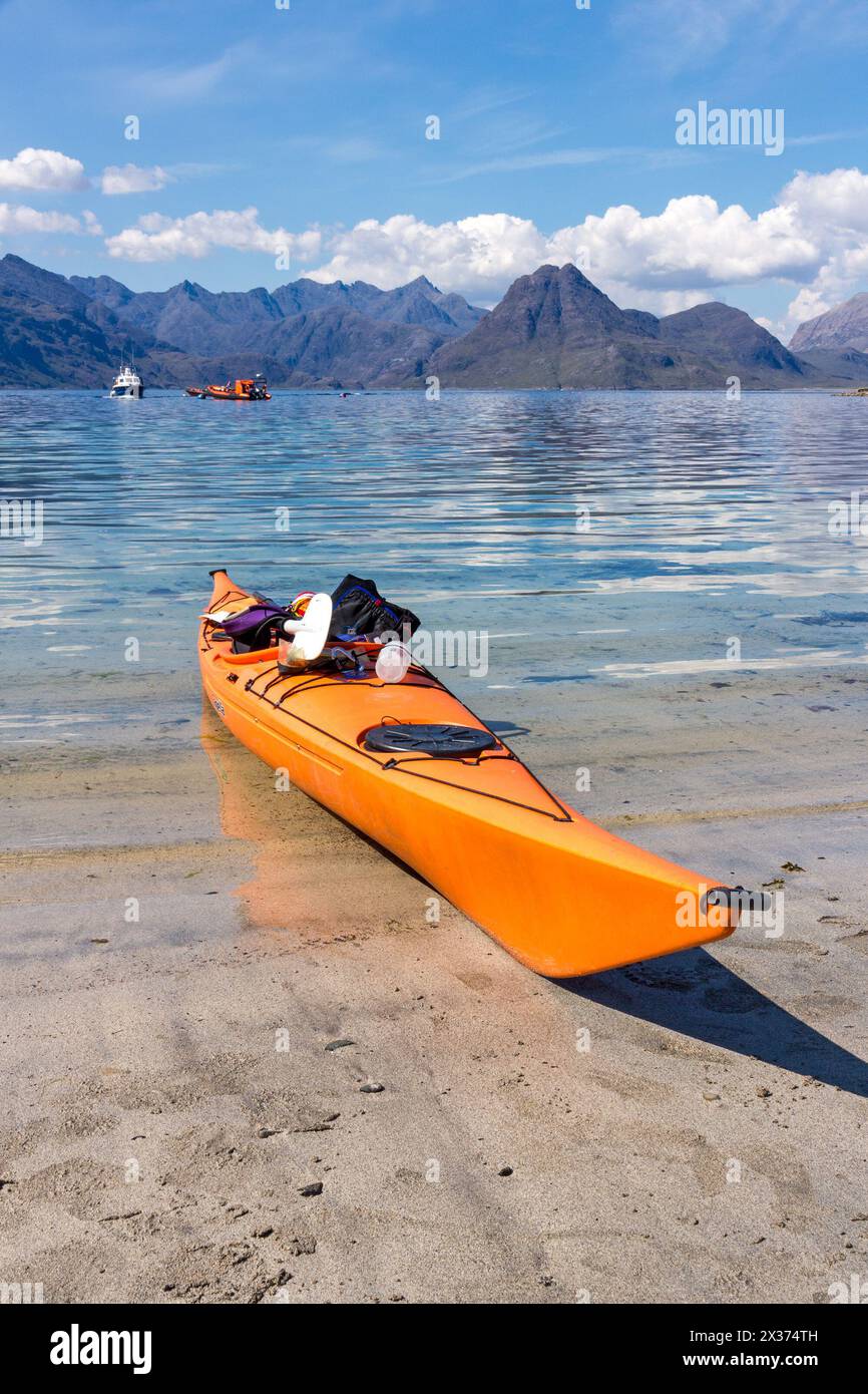 Arancio brillante kayak di mare sulla spiaggia di Elgol con mare Loch Scavaig e nero montagne Cuillin oltre, Isola di Skye, Scotland, Regno Unito Foto Stock