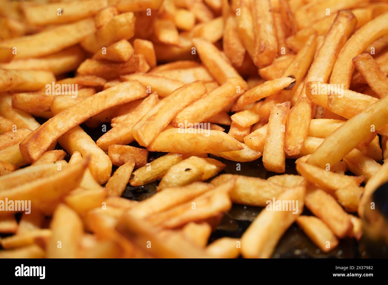 Primo piano di patatine fritte oleose sullo sfondo delle patate. Foto Stock
