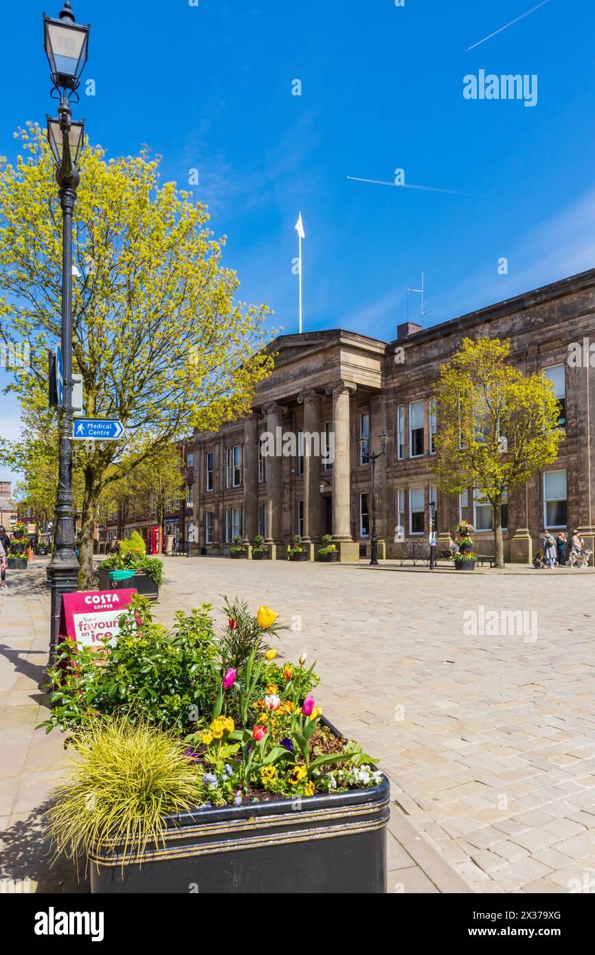 Il Municipio di Macclesfield e la piazza del mercato in una mattinata di aprile soleggiata con alberi e fiori Foto Stock