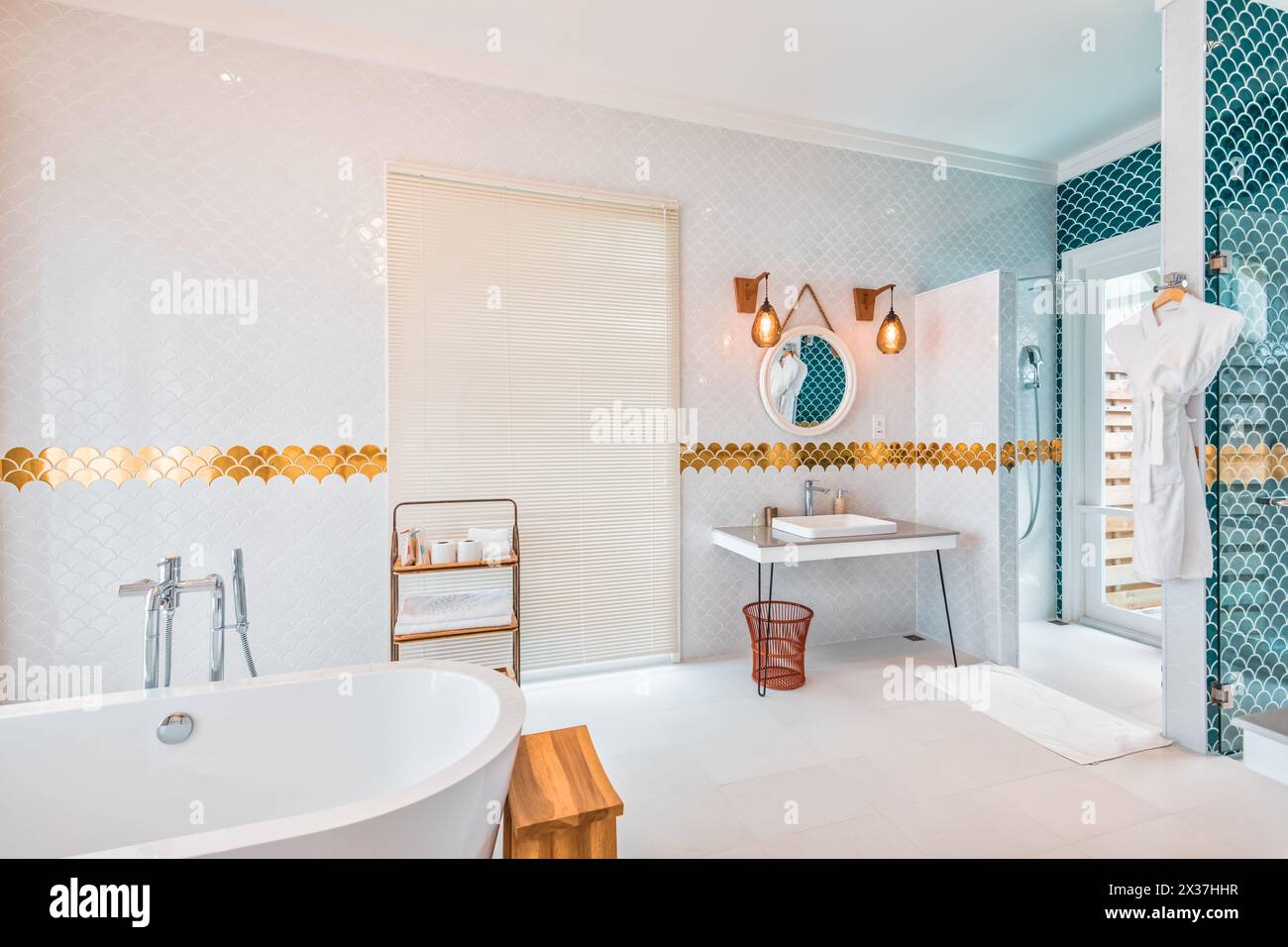 Splendido bagno di lusso con lavandino blu, vasca e doccia separate, rubinetti e decorazioni dorate. Interni eleganti Foto Stock