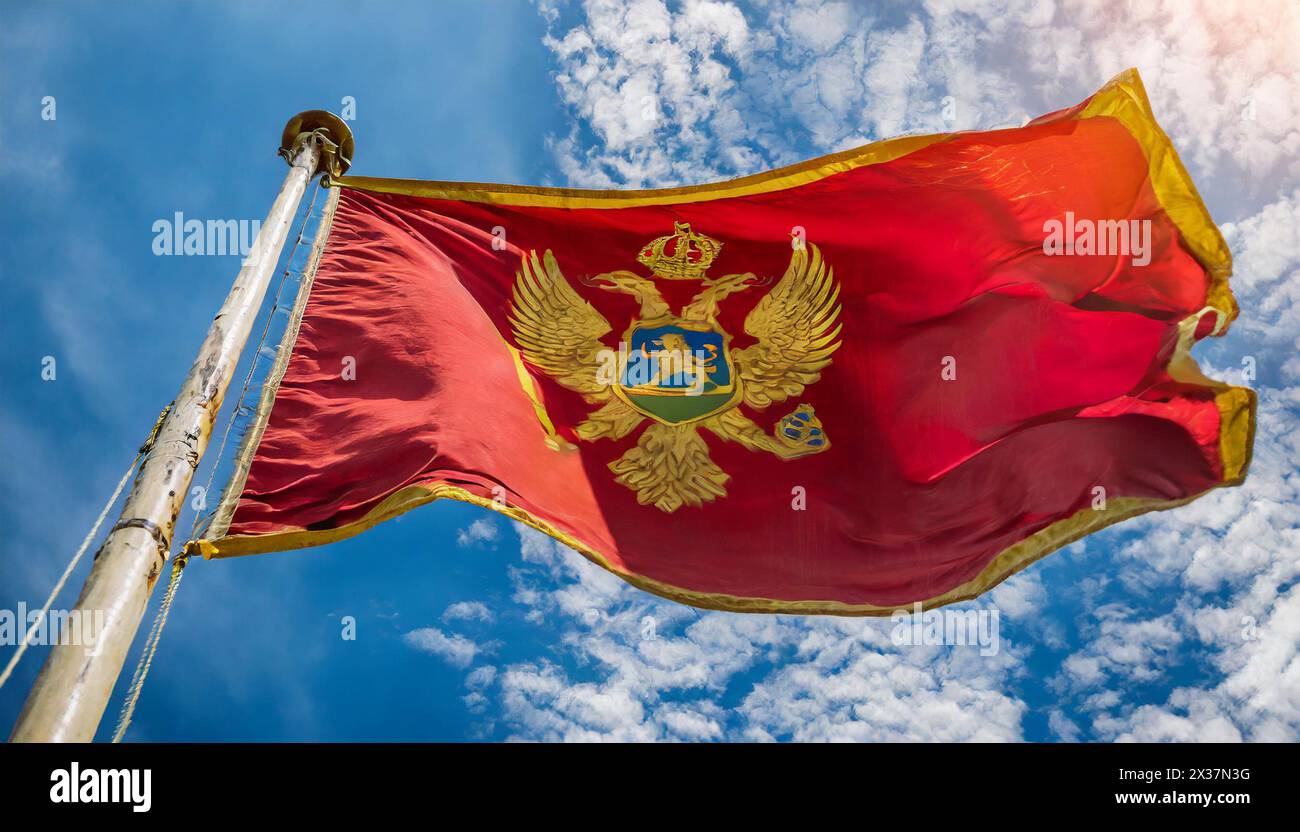 Fahnen, Die Nationalfahne von Montenegro flattert im Wind Foto Stock