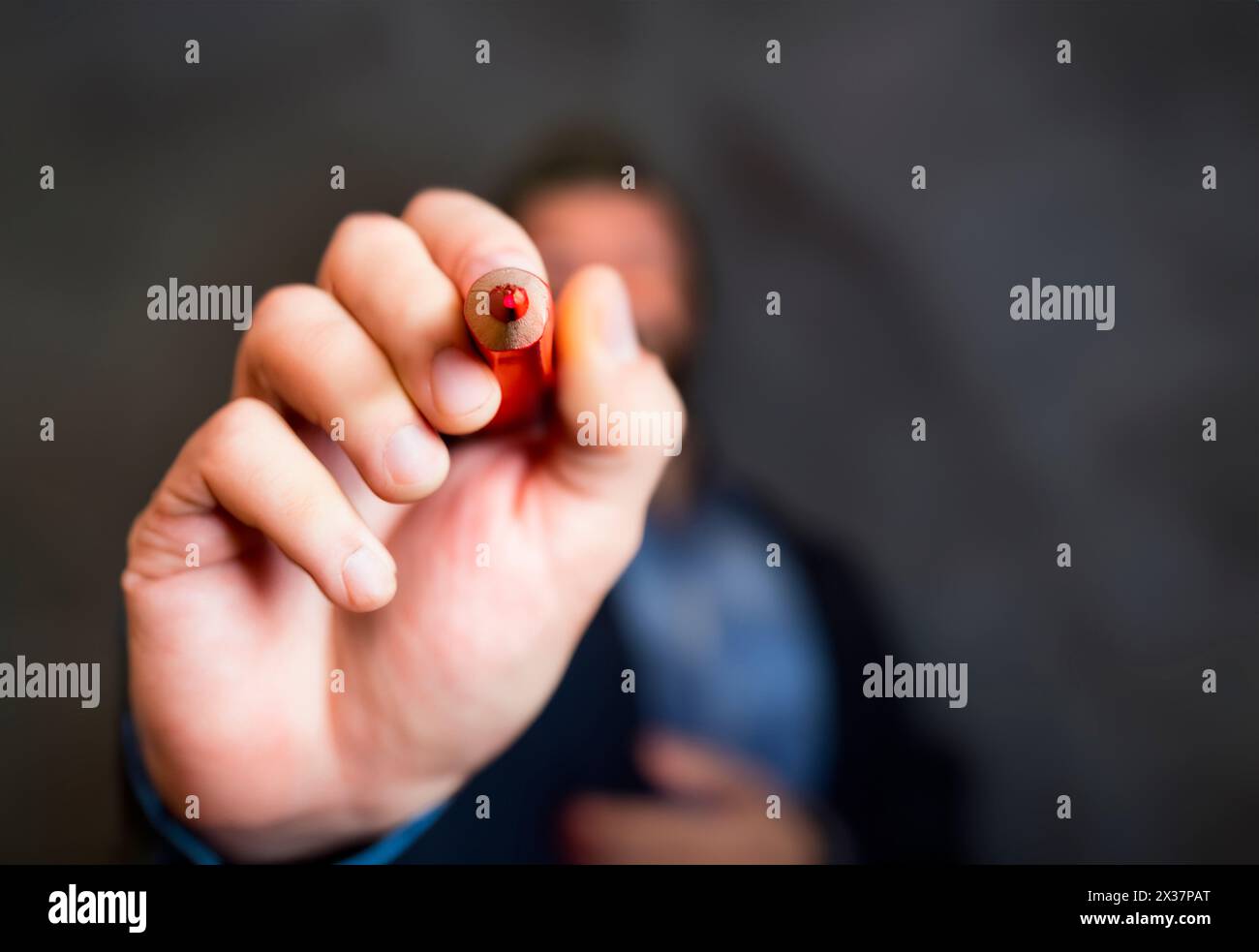 Punta della matita rossa punta verso la fotocamera e verso di te. Matita con scrittura di colore rosso. Votate. Concentrarsi sul pdi rosso acuto Foto Stock