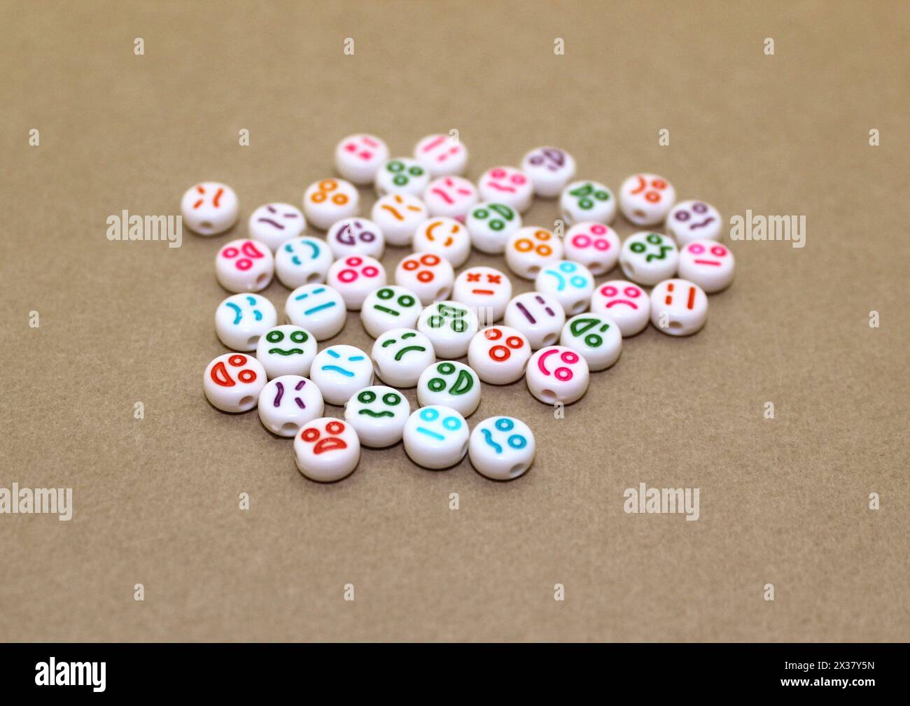 Perline decorative in plastica con volti divertenti. Pietre decorative bianche per la collana. Foto Stock