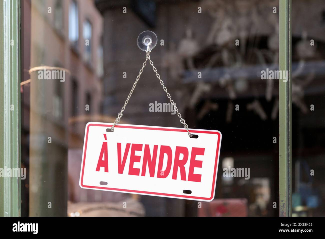 Primo piano su un cartello rosso in una finestra con scritto in francese "à vendre", che in inglese significa "in vendita". Foto Stock