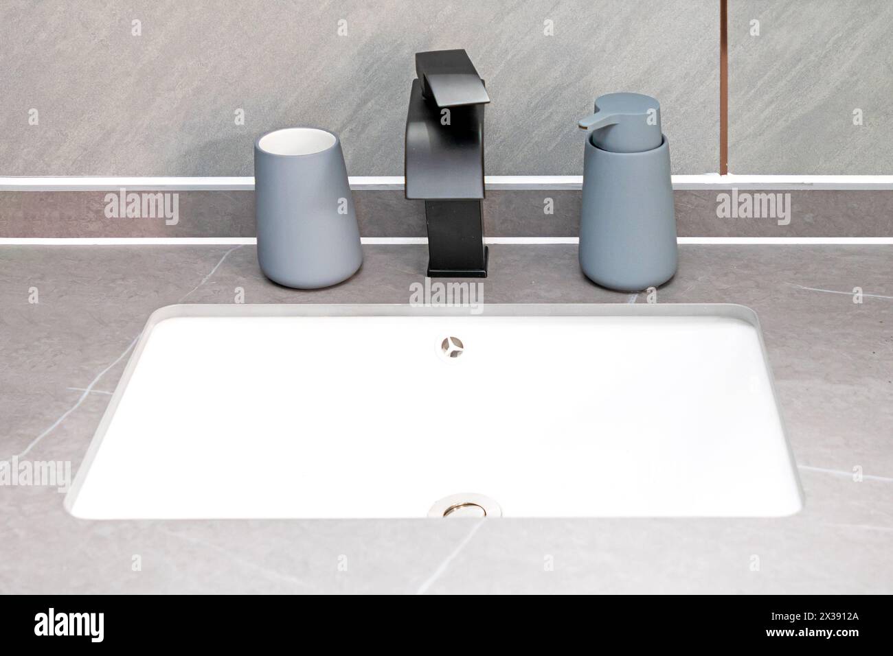 Bagno moderno con lavandino in marmo e decorazioni in rubinetti neri Foto Stock