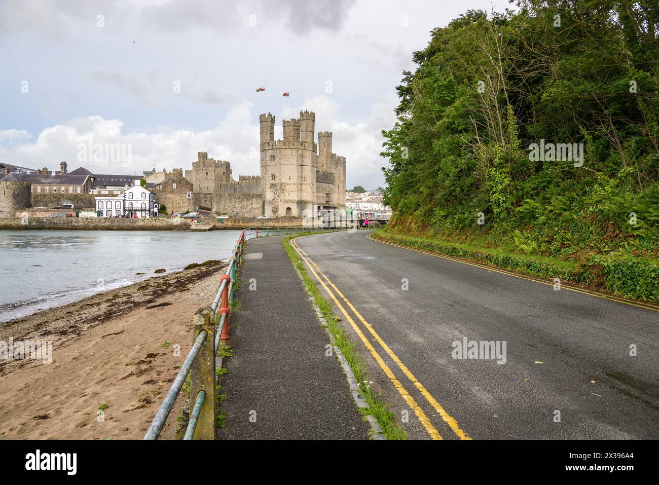 Vista del castello di Caernarfon da Aber Foreshore Road in un giorno estivo parzialmente nuvoloso Foto Stock