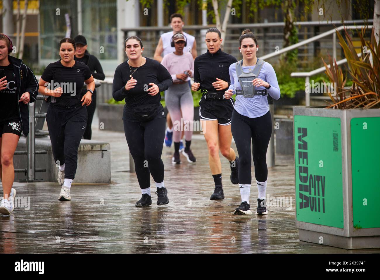 MEDIACITYUK Salford Quays sviluppo del lungomare nel gruppo GTR Manchester di persone che corrono Foto Stock