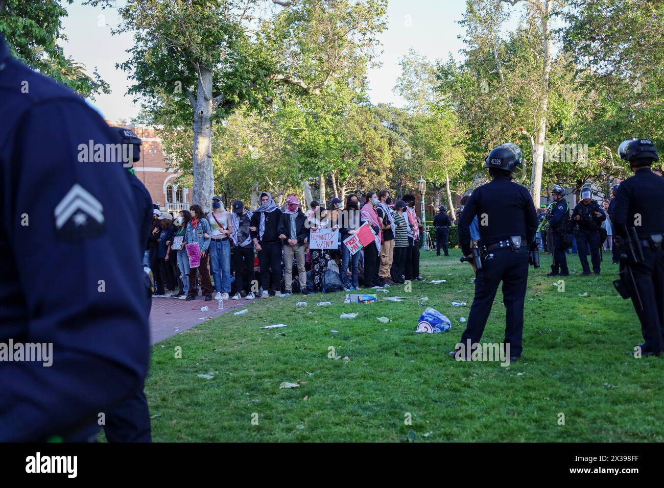 Los Angeles, California, Stati Uniti 24 aprile 2024. Lasciate che l'umanità vinca il segno tenuto dal manifestante in mezzo all'erba, dove sono stati avvertiti che sarebbero stati arrestati presto. La University of Southern California (USC) è stata chiusa il 24 aprile 2024 a causa di una grande protesta pro-Palestina/Hamas. Centinaia di studenti universitari e altri che sono venuti illegalmente nel campus hanno portato a oltre 50 arresti da parte di agenti del Los Angeles Police Department (LAPD) di fronte al Center for International and Public Affairs Building. (Immagine di credito: © Amy Katz/ZUMA Press Wire) SOLO PER USO EDITORIALE! Non per USO commerciale! Foto Stock