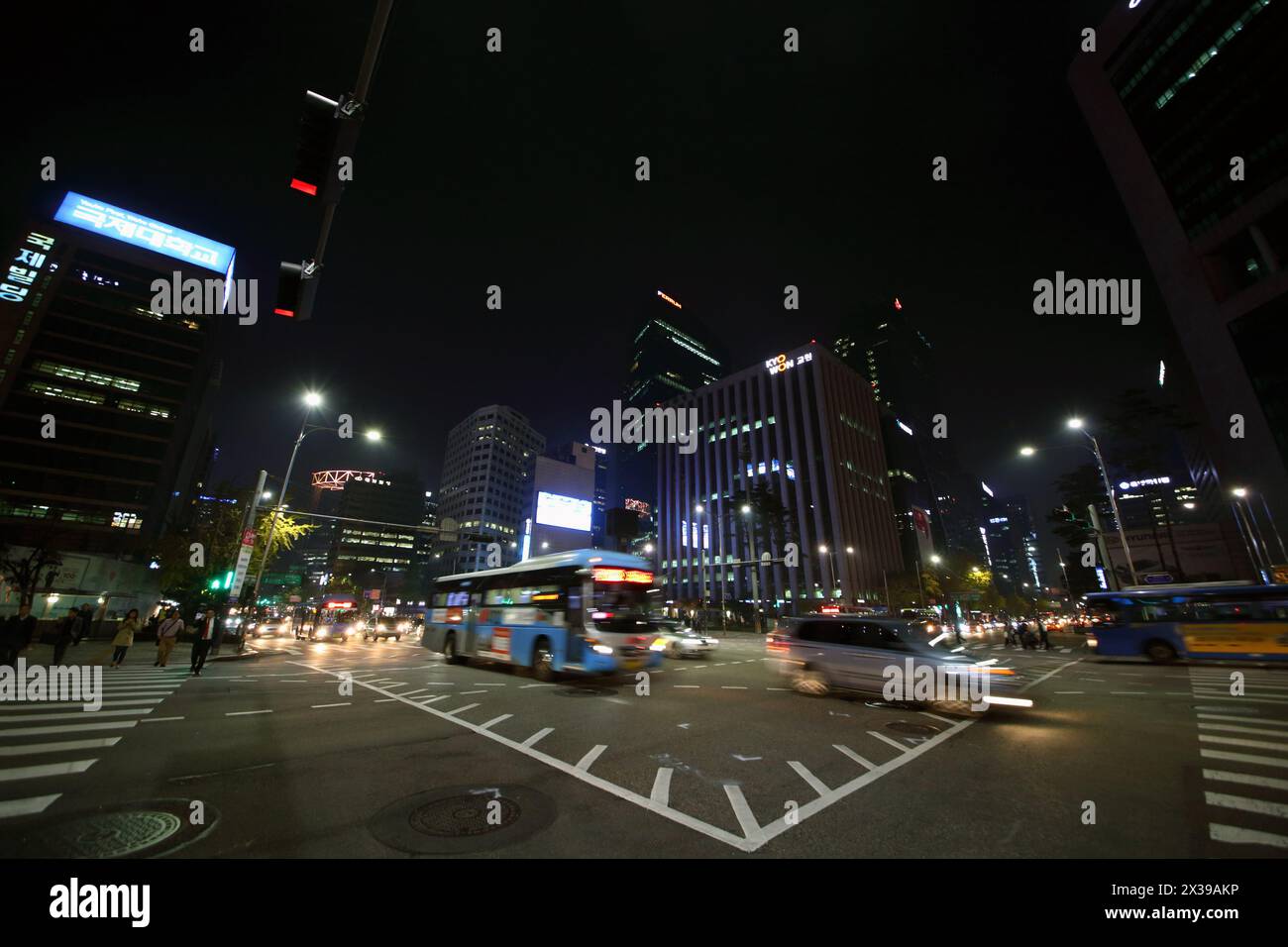 SEOUL - novembre, 3, 2015: Le persone che attraversano la strada sul marciapiede e le auto si muovono di notte. I pedoni a Seoul possono ora raggiungere in modo più sicuro le strade del centro di sono Foto Stock