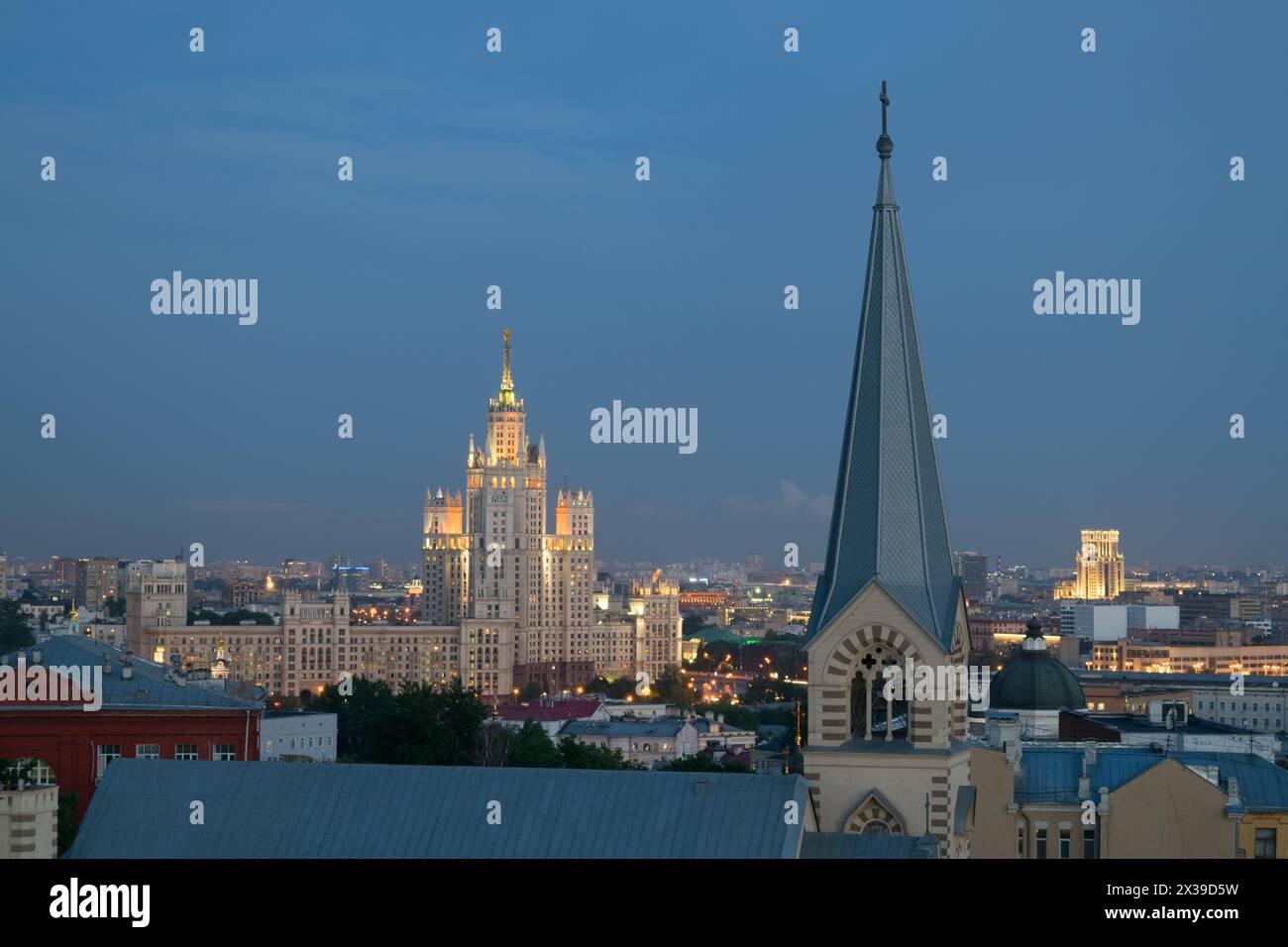 Chiesa evangelica luterana di San Peter e St. Paul e il grattacielo stalinista sul molo Kotelnicheskaya di notte a Mosca Foto Stock