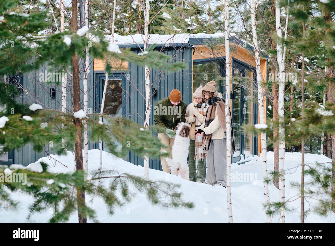 Ampia scelta di una moderna famiglia caucasica di tre persone con animali domestici che trascorrono la giornata invernale all'aperto, spazio fotocopie Foto Stock