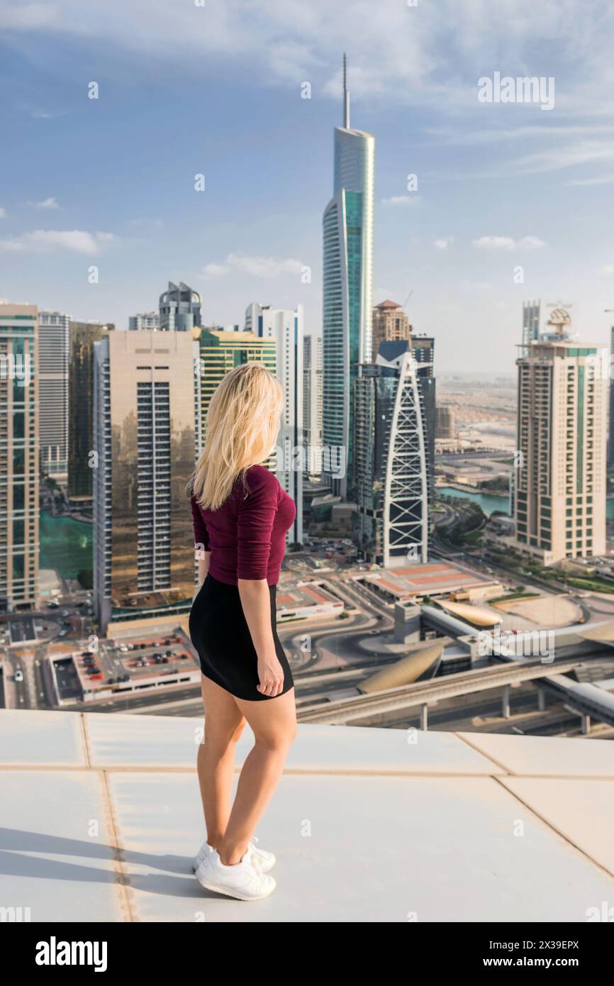 DUBAI, Emirati Arabi Uniti - 13 GENNAIO 2017: Donna sul tetto di Almas Tower, Indigo Tower, Palladium, Lake City Tower, Global Lake View, autostrada, ogni anno in più Foto Stock