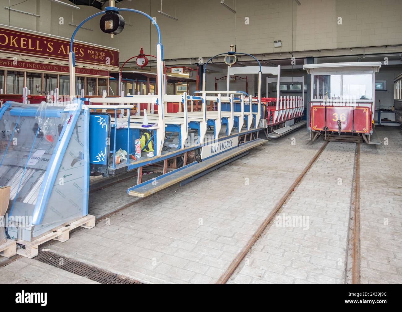 Guardando attraverso la porta cordata che conduce ai capannoni dei tram si scopre una serie di tram, tra cui un toastrack. Questi sembrano essere tram d'epoca originali. Foto Stock