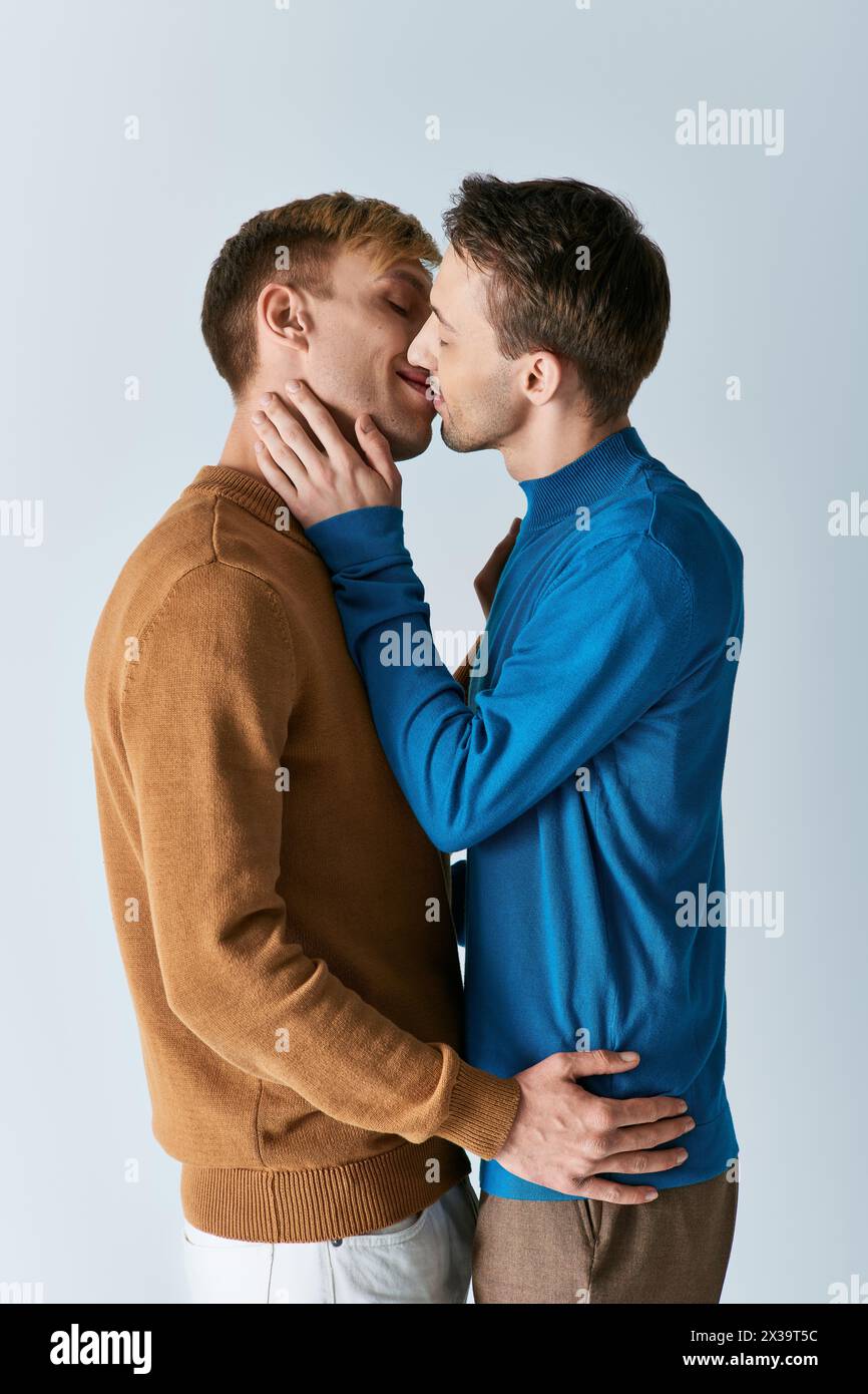 Due uomini, una coppia gay amorevole, stanno fianco a fianco su uno sfondo bianco. Foto Stock