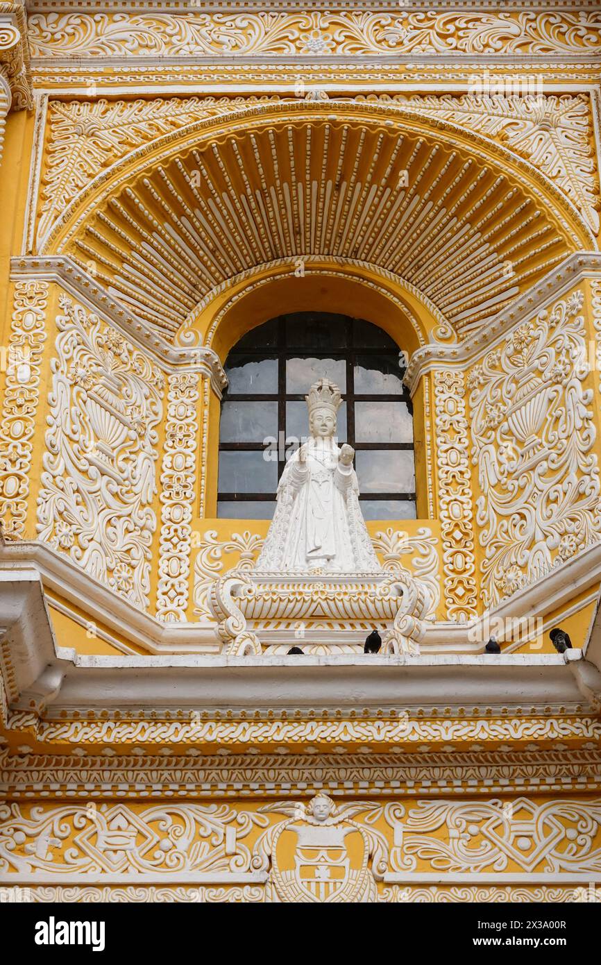 Una statua della Beata Vergine Maria della Misericordia decora la facciata della Chiesa e del Convento di la Merced, una chiesa cattolica ornata costruita in stile churrigueresco nel 1749 ad Antigua, Guatemala. Foto Stock