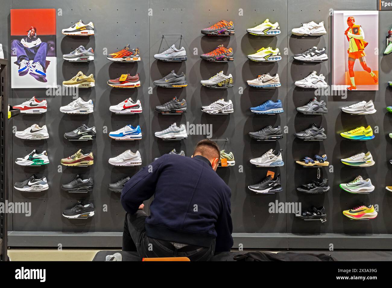 Un'ampia selezione di scarpe atletiche Nike sugli scaffali del negozio dell'azienda. Il cliente sceglie le sneakers per l'acquisto. Minsk, Bielorussia - 24 aprile 2024 Foto Stock