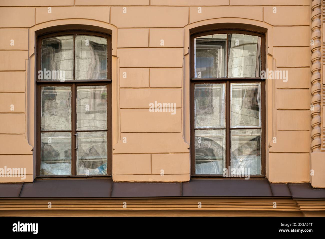Due finestre rettangolari con vecchie cornici in legno marrone con riflessi sul vetro, contro una parete beige. Dalla serie Window of the World. Foto Stock