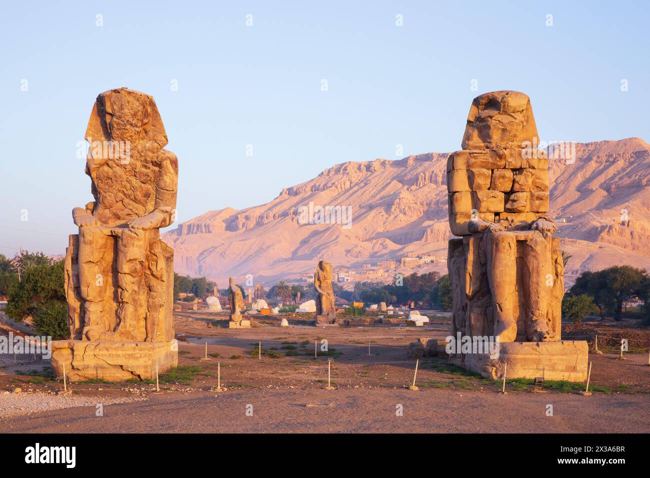 I Colossi di Memnone (statue colossali del faraone Amenofi III) all'alba sulla sponda occidentale di Luxor, Egitto Foto Stock