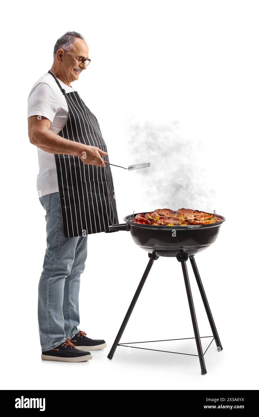 Uomo maturo che grigia la carne su un barbecue isolato su sfondo bianco Foto Stock
