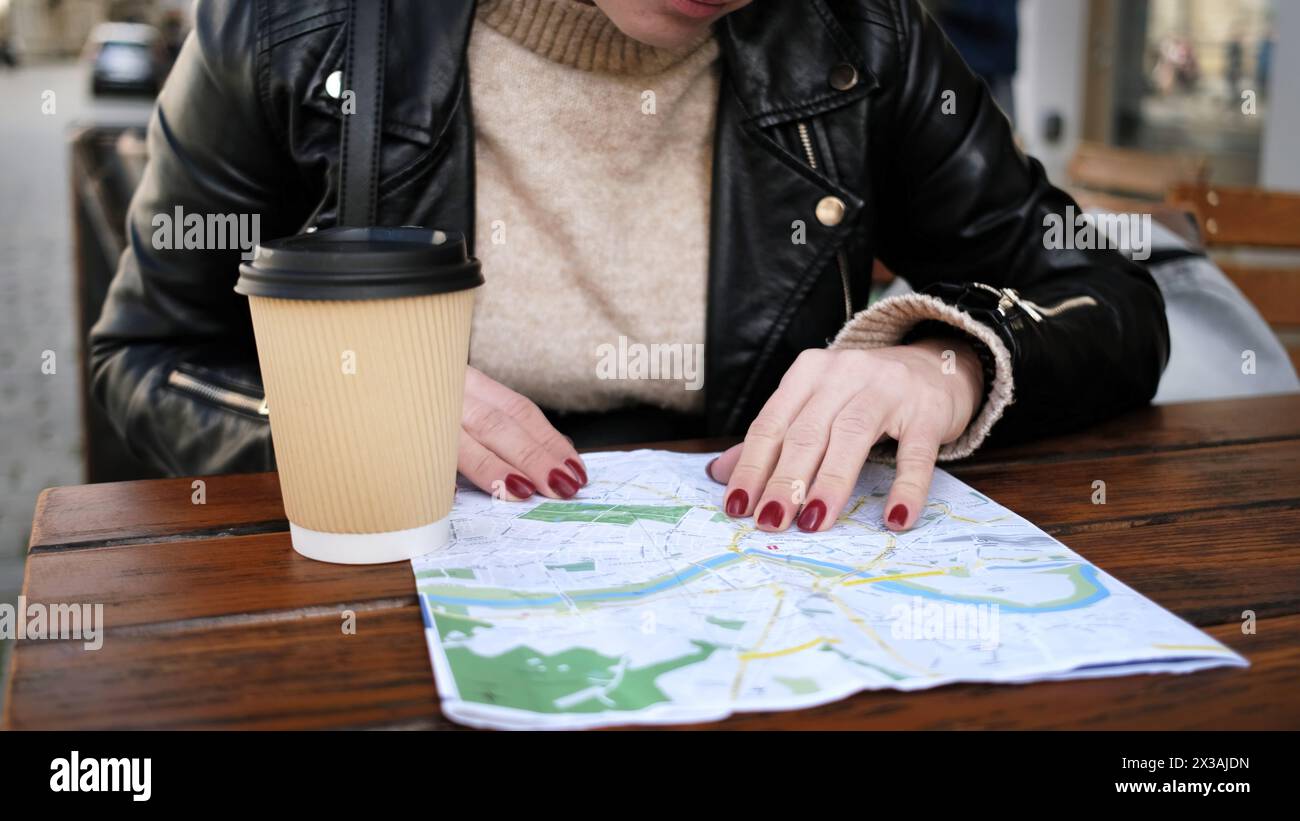 Elegante percorso Turistico della città femminile sulla mappa mentre sorseggi un caffè in Street Cafe Foto Stock