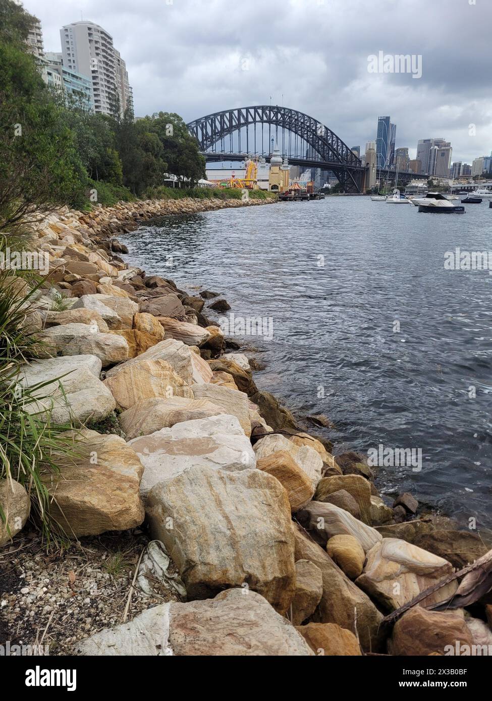 Il litorale del porto di Sydney si affaccia sul famoso ponte del porto di Sydney in una giornata nuvolosa Foto Stock