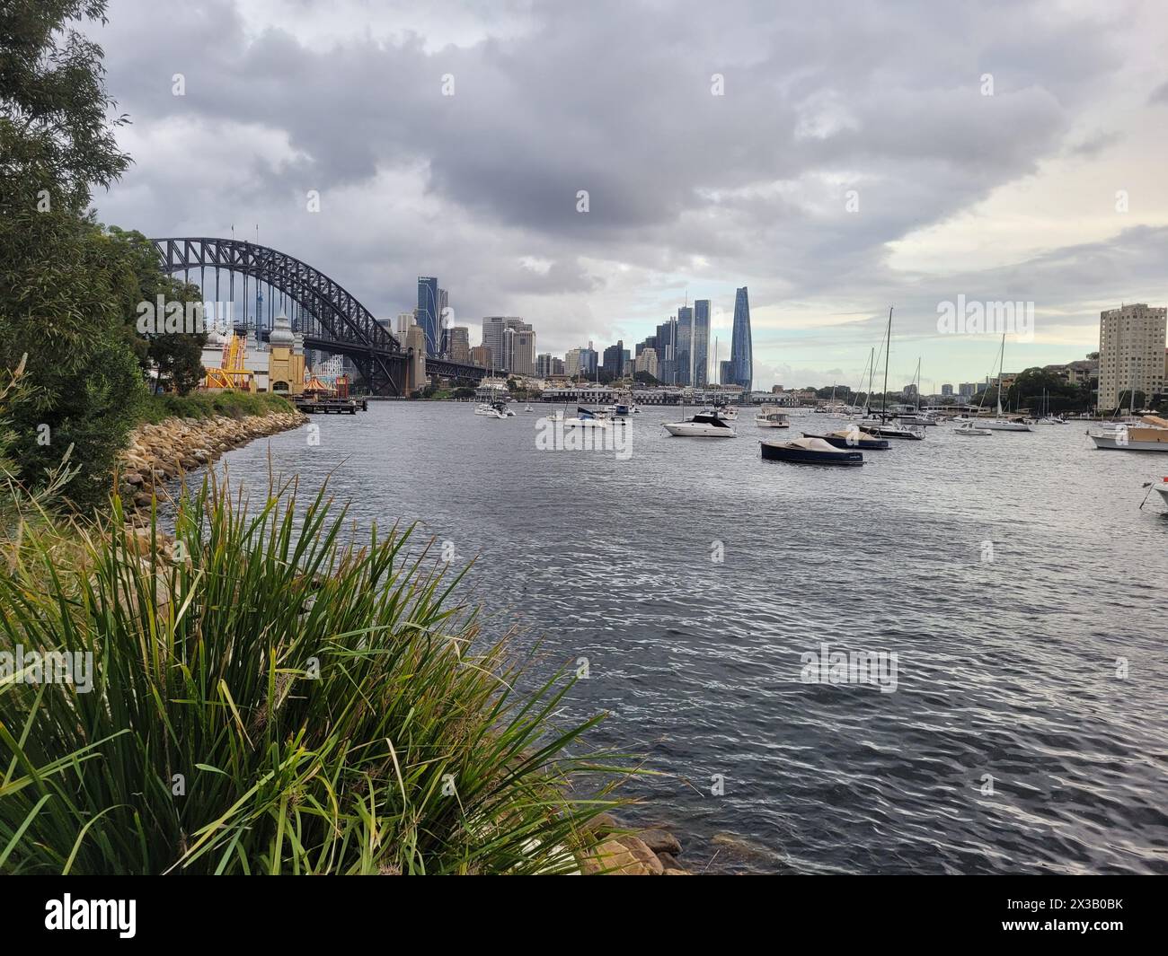 Il litorale del porto di Sydney si affaccia sul famoso ponte del porto di Sydney in una giornata nuvolosa Foto Stock