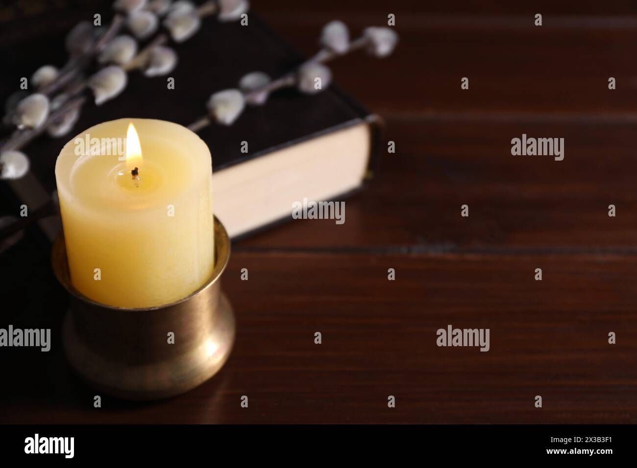 Candela accesa su un tavolo di legno, primo piano. Spazio per il testo Foto Stock