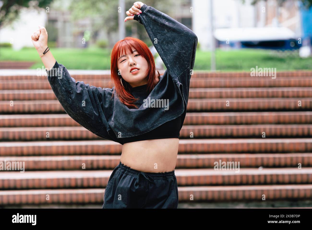 Ballerina coreana che esprime gioia attraverso la danza su una scala della città Foto Stock