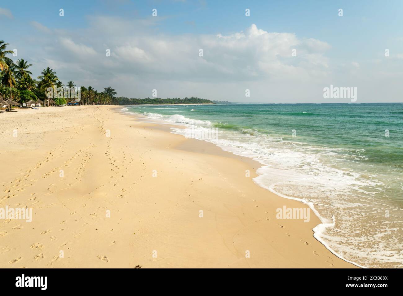 Splendida immagine di sfondo della spiaggia tropicale. Sole estivo sull'oceano. Cielo blu con nuvole chiare, oceano turchese con surf e sabbia limpida. Danno Foto Stock