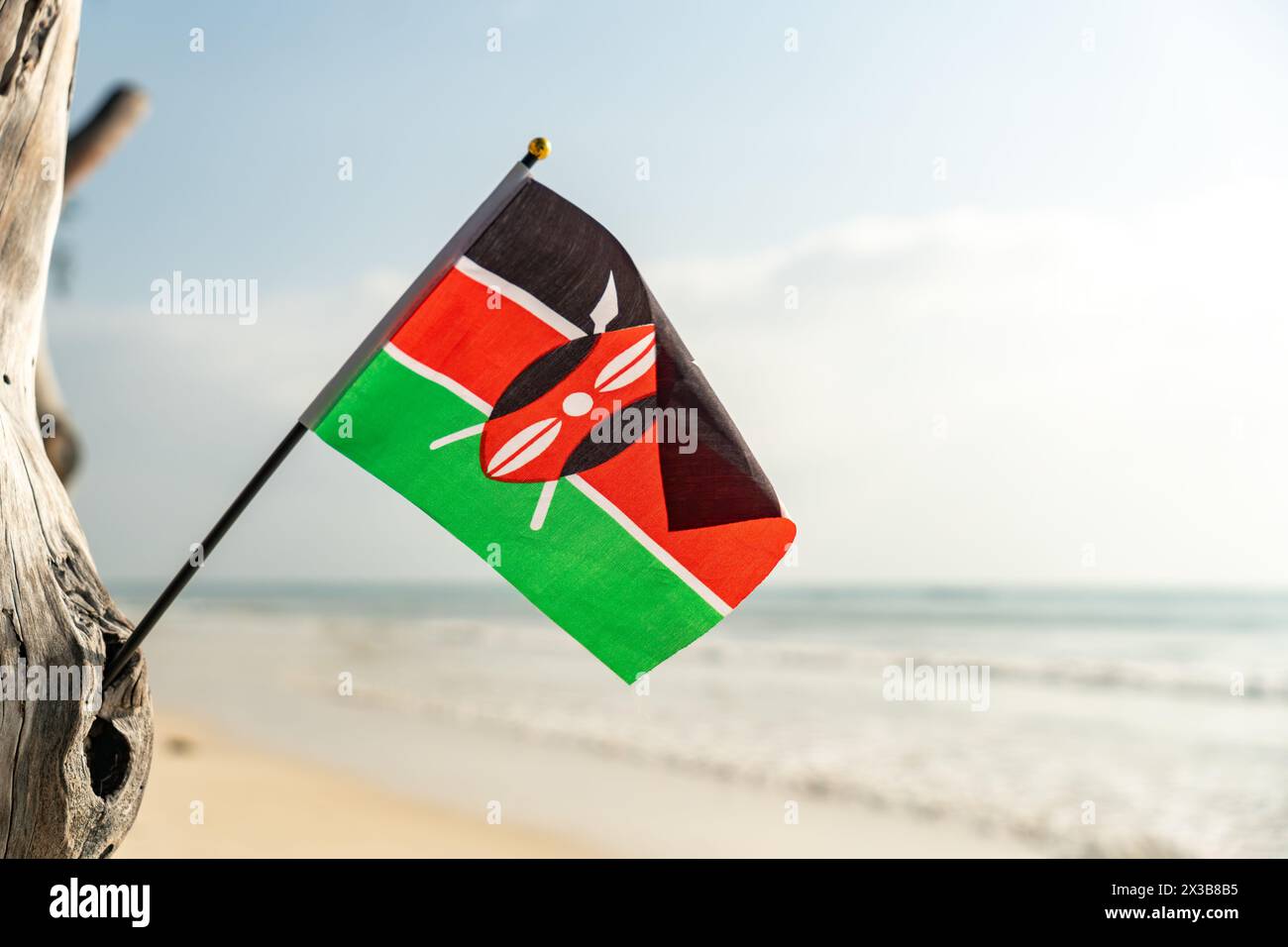 La bandiera del Kenya su una bellissima spiaggia di sabbia bianca e pulita. Il concetto di ricreazione nella Repubblica keniota. Foto Stock