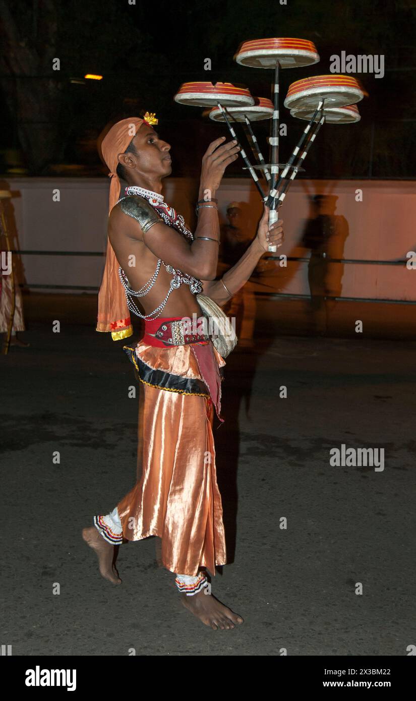 Un ballerino Tambourine o Rabun Nettuwo si esibisce lungo una strada a Kandy in Sri Lanka durante l'Esala Perahera (grande processione). Foto Stock