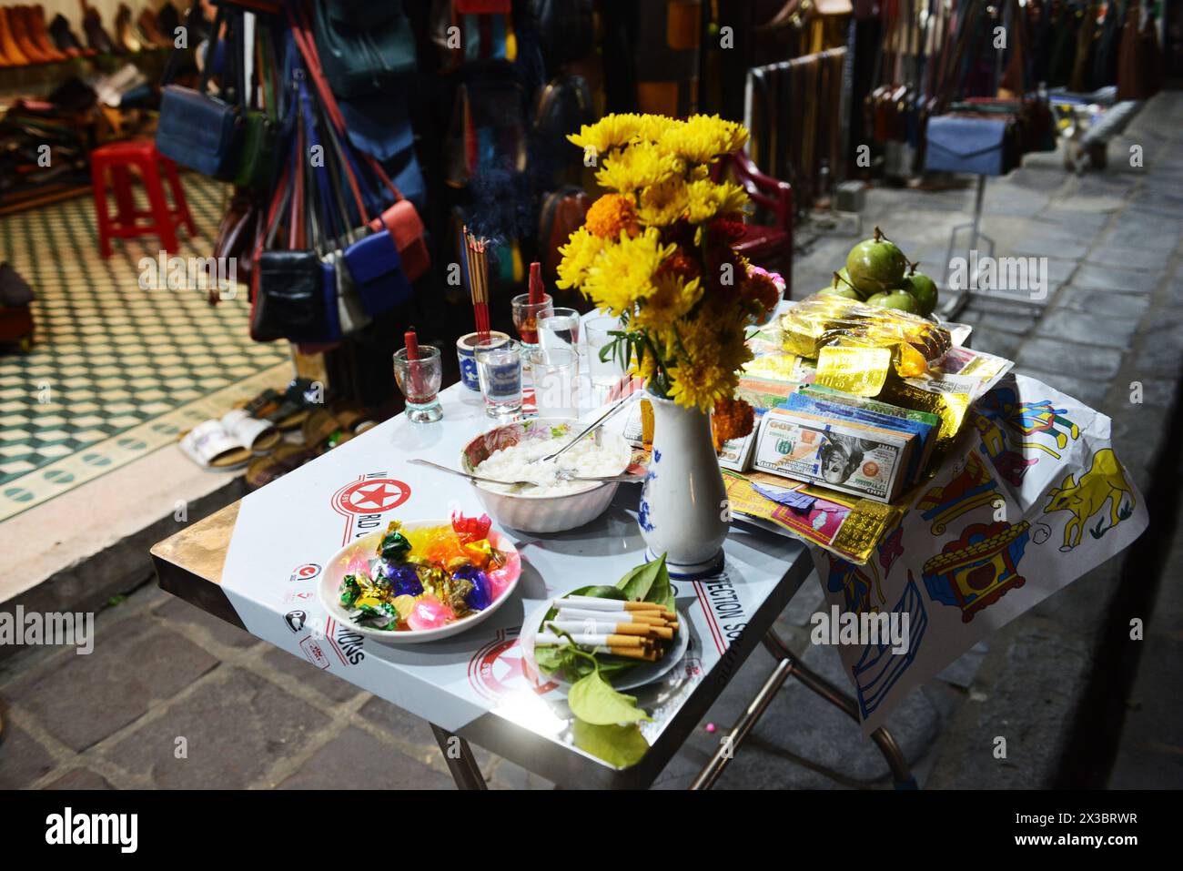 Un tavolo con regali di buona fortuna e fascino fuori da un negozio a Hoi An, Vietnam. Foto Stock