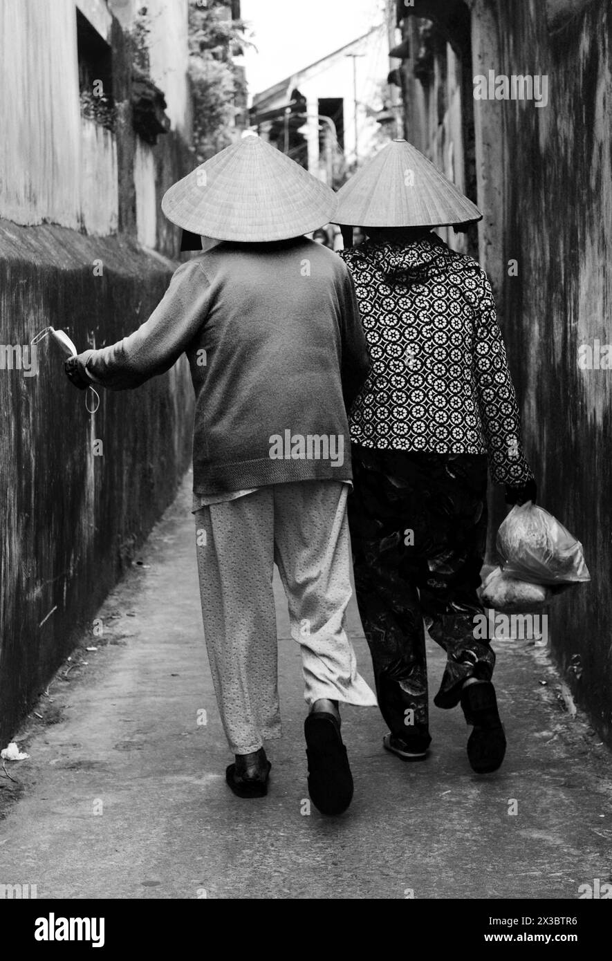 Donne vietnamite che camminano nella città vecchia di Hoi An in Vietnam. Foto Stock