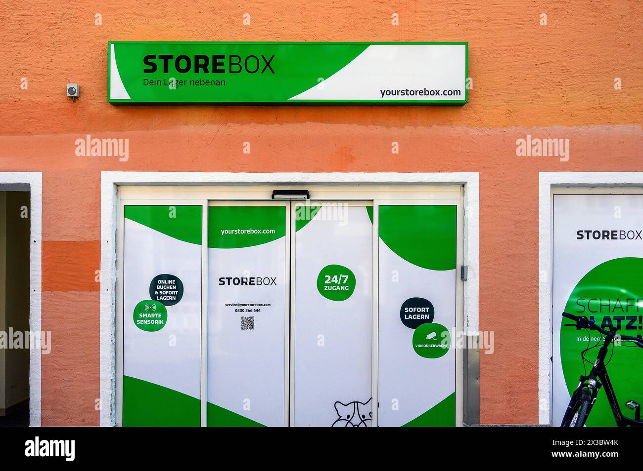 Facciata di colore arancione con pubblicità STOREBOX, Allgaeu, Svevia, Baviera, Germania Foto Stock