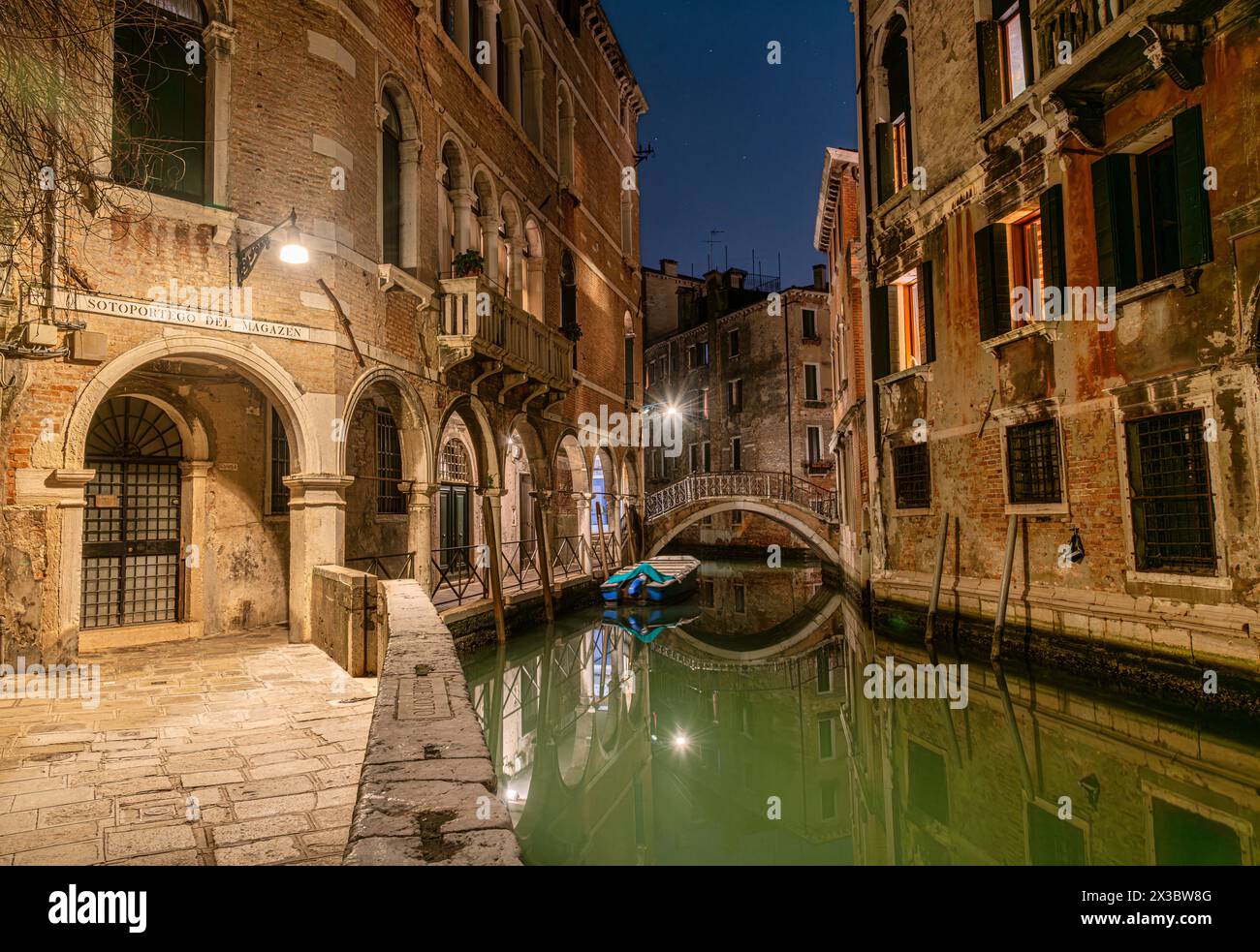 Un pittoresco canale laterale stretto a Venezia di notte. Foto Stock