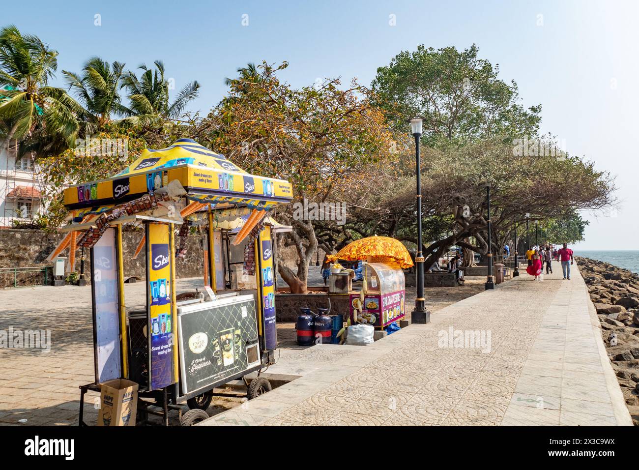 Cochin, India - 22 marzo 2024: Persone sul lungomare di Kochi, India, con falchi che vendono dolci, cibo e bevande. Foto Stock