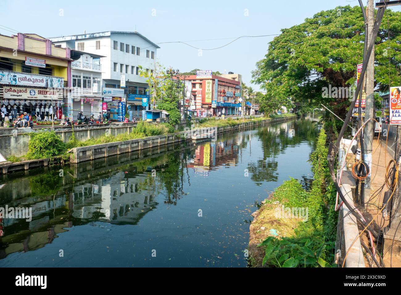 Cochin, India - 22 marzo 2024: Persone nella via dello shopping di Cochin sul vecchio canale con riflessi in acqua. Foto Stock